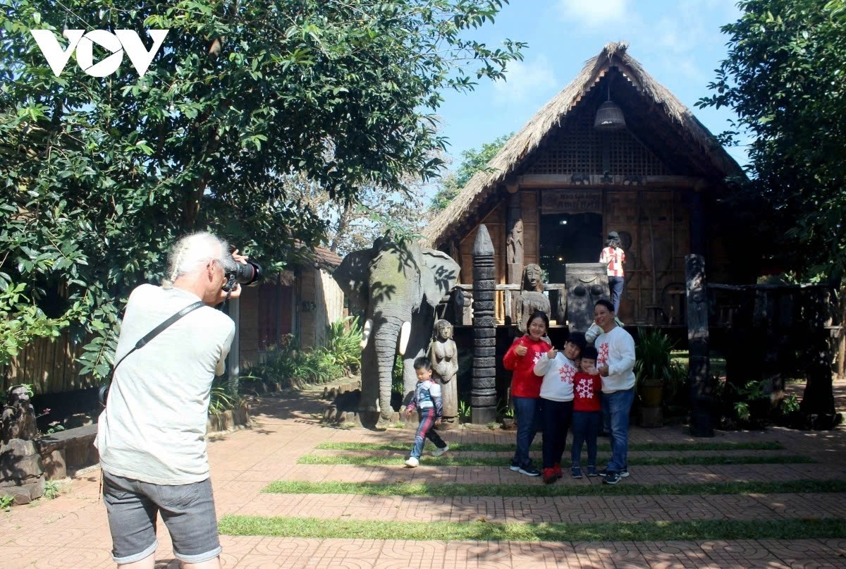 Visitors take photos by E De longhouses, elephant statues and iconic images of the Central Highlands.