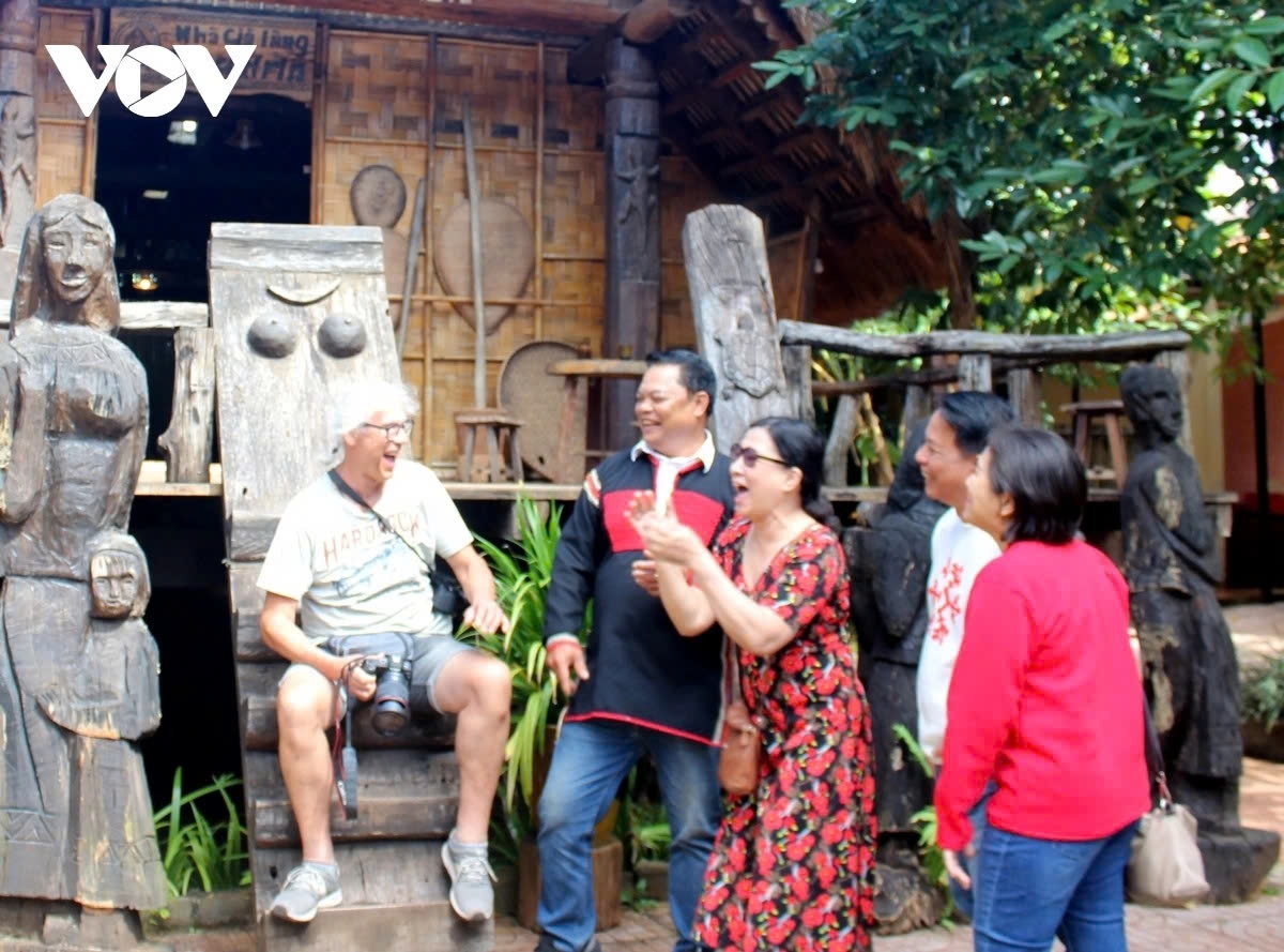Village elders explain the architecture and cultural significance of E De longhouses to visitors.