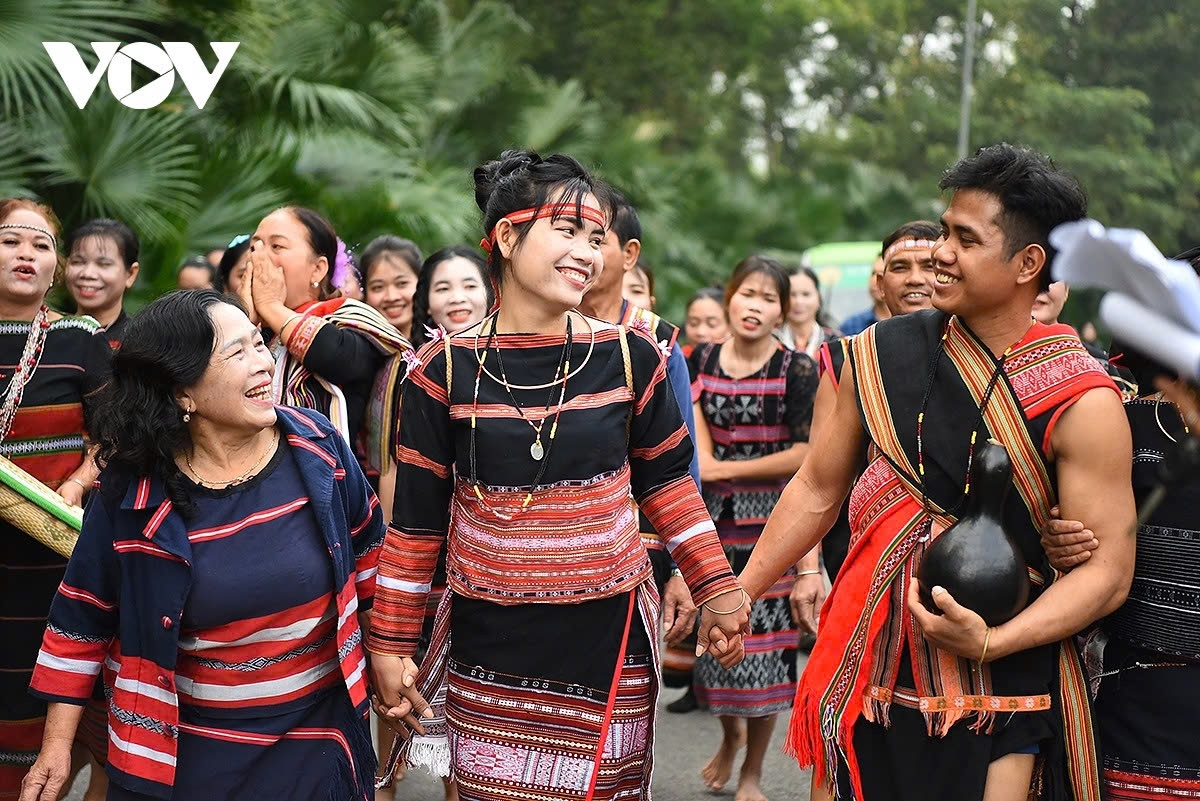 The groom's mother presents a bronze ring to the bride as a welcoming gesture, expressing joy and happiness while receiving a new member to the family.