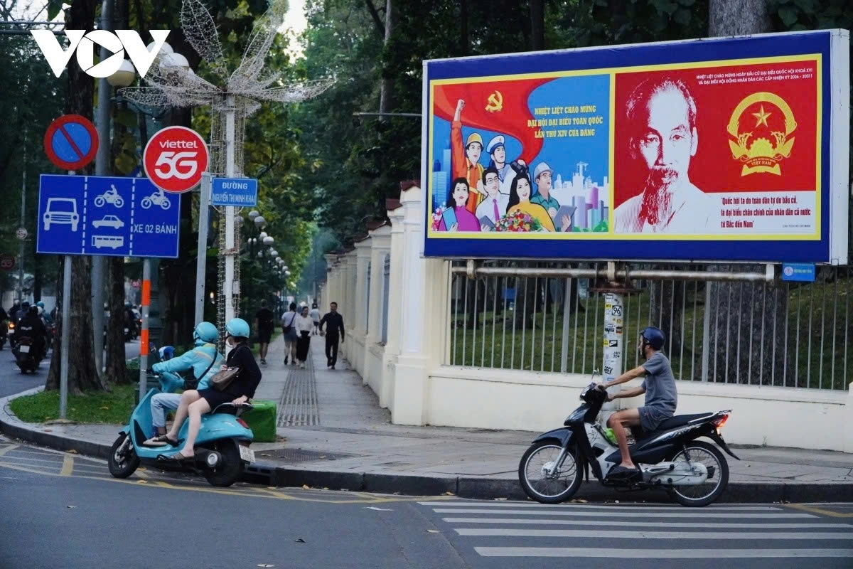 A large poster welcoming the 14th National Party Congress stands at the intersection of Nguyen Thi Minh Khai and Nam Ky Khoi Nghia streets.