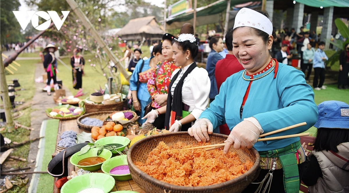 Ethnic minority people from northern highlands demonstrate the making of five-colour sticky rice at the market fair.