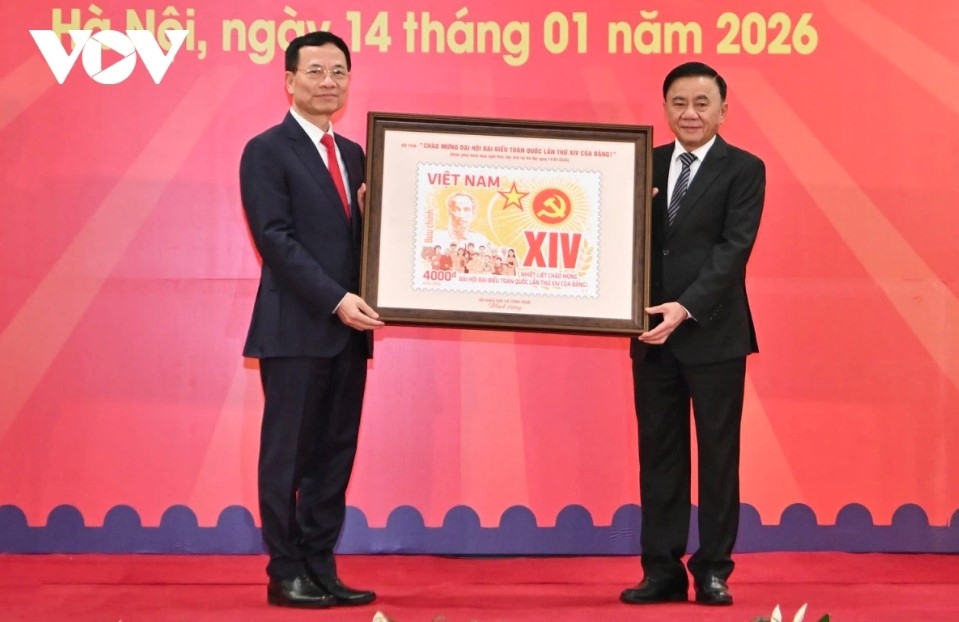Minister of Science and Technology Nguyen Manh Hung presents a framed set of commemorative postage stamps titled “Welcoming the 14th National Party Congress ” to Standing Secretariat member Tran Cam Tu.