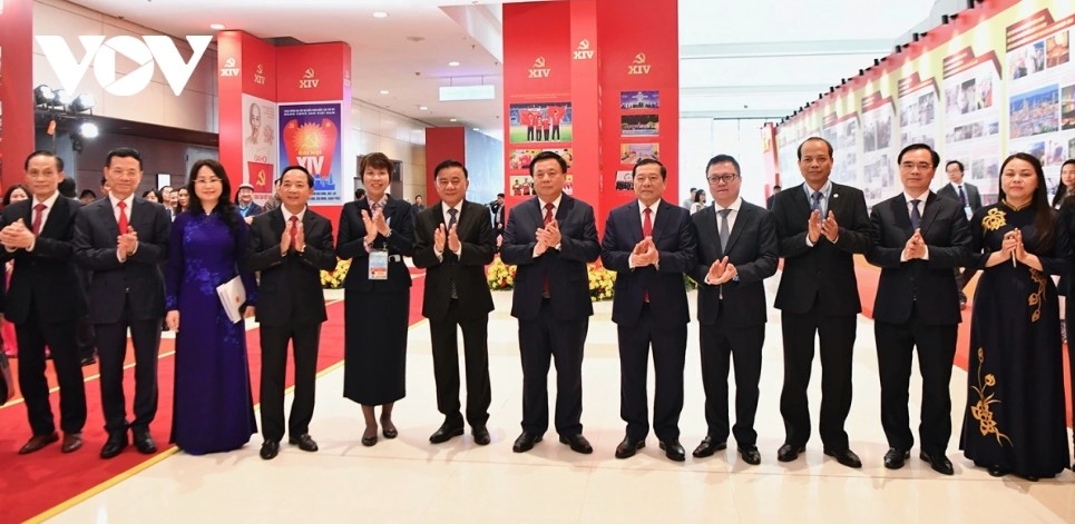 Permanent member of the Party Central Committee’s Secretariat Tran Cam Tu and delegates pose for a group photo at the exhibition area inside the National Convention Center.