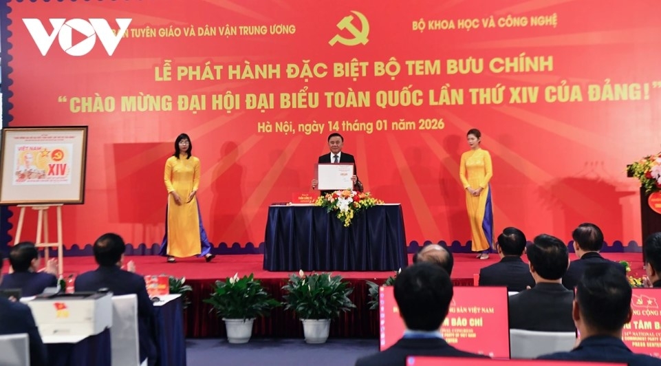 Standing Secretariat member Tran Cam Tu shows the special stamp set marking the 14th National Party Congress