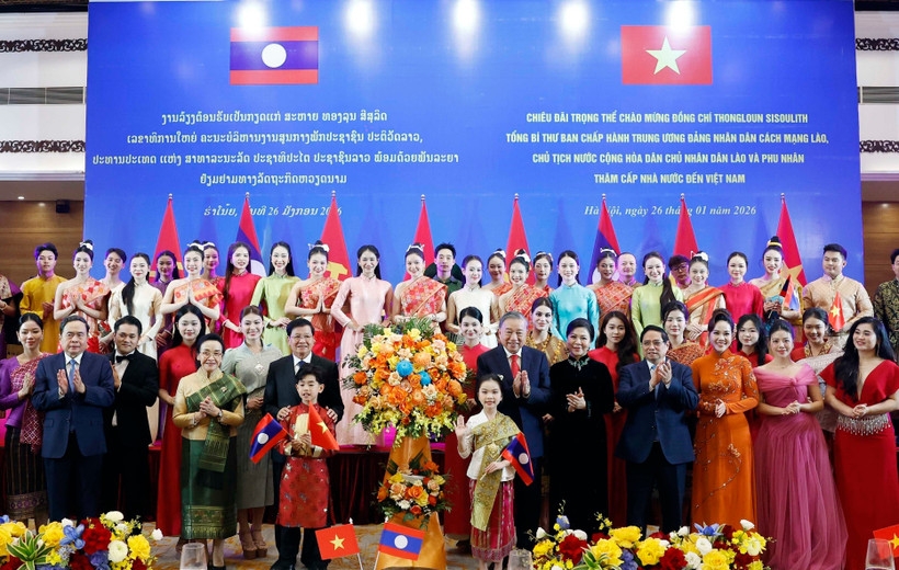 Party General Secretary To Lam and his spouse, together with Party General Secretary and President of Laos Thongloun Sisoulith and his spouse, present flowers to artists at the banquet. (Photo: VNA)