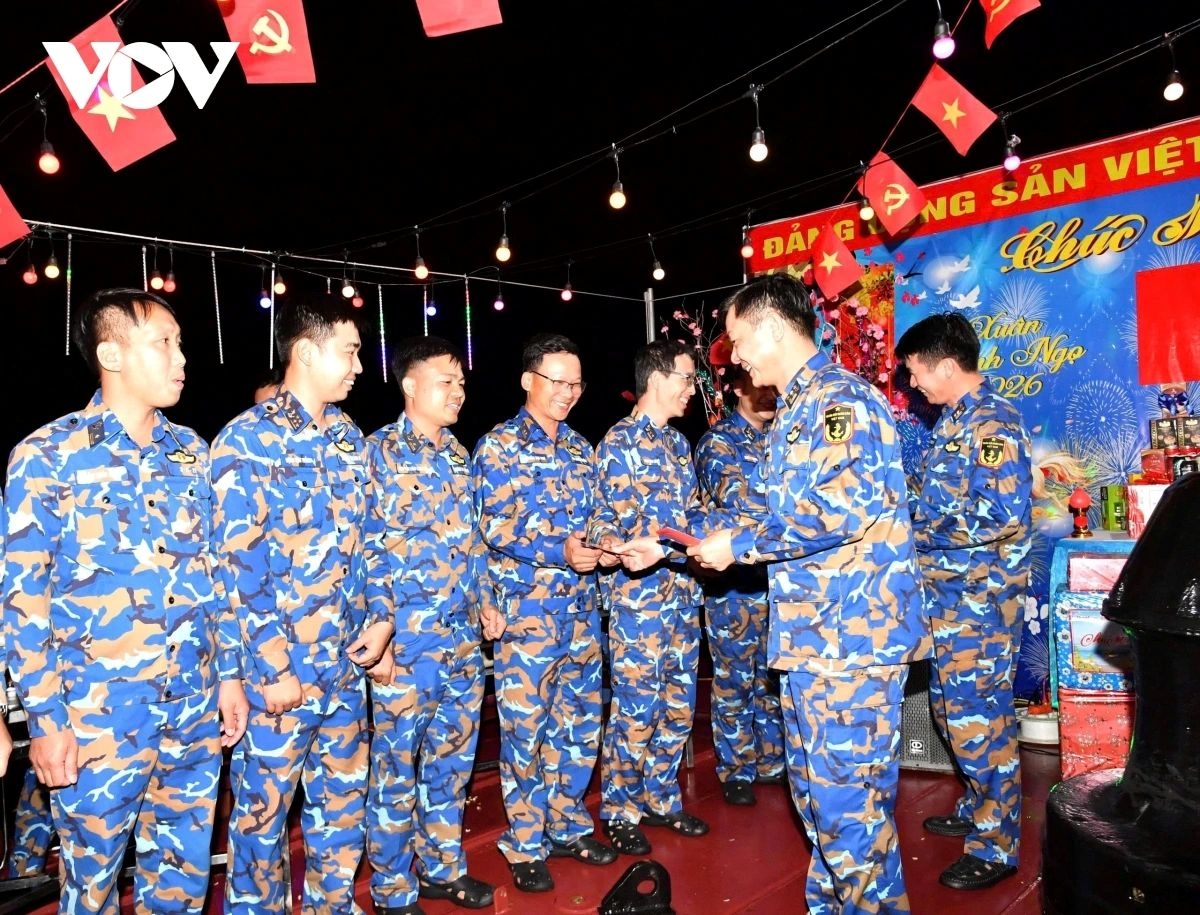 The head of the mission presents lucky money to crew members.