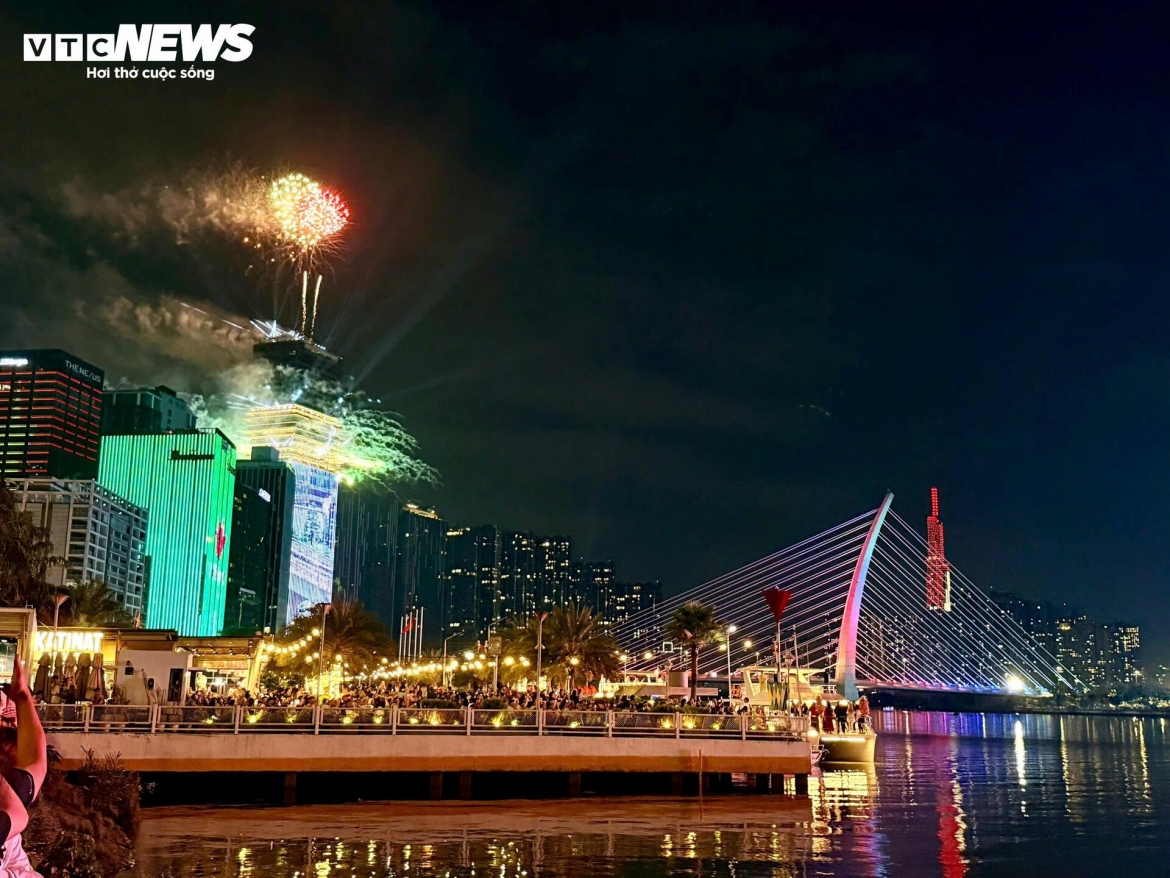 At exactly midnight on February 17, the first day of the Lunar New Year, the initial bursts of fireworks are launched simultaneously from the area at the entrance to the Saigon River tunnel in Ho Chi Minh City, lighting up the skyline as crowds cheer the arrival of the new year.