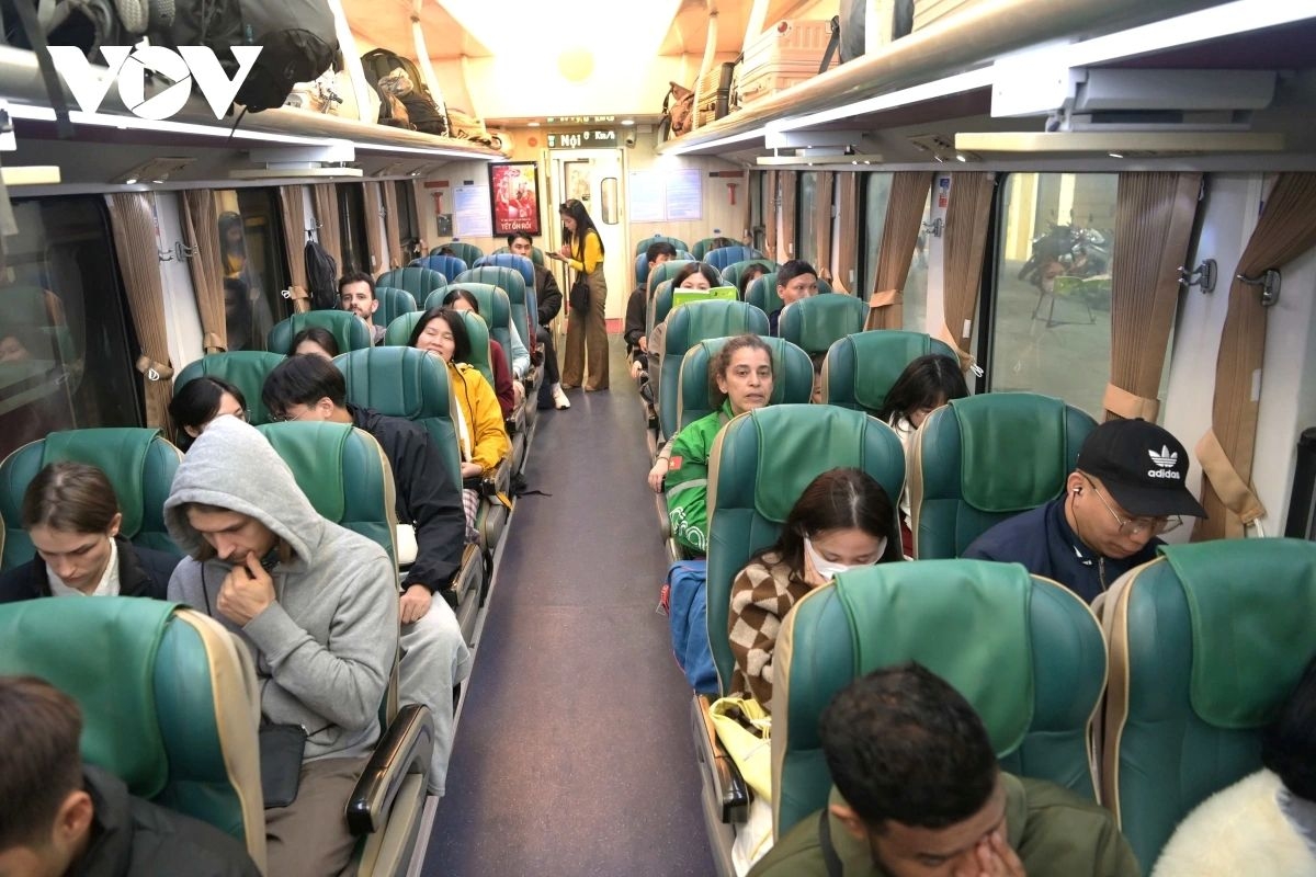 Foreign tourists receive lucky money envelopes aboard the “Happiness” train as part of the Lunar New Year celebrations.