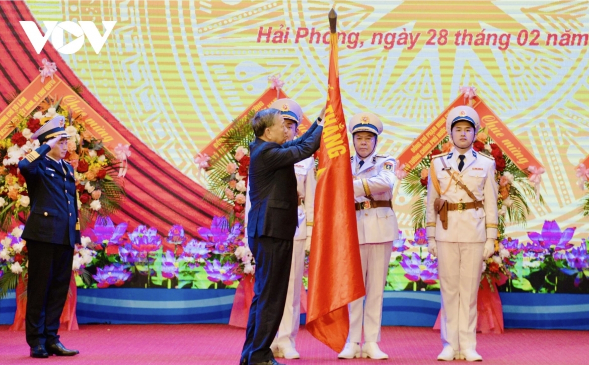 Party General Secretary To Lam pins the Hero of the People’s Armed Forces badge onto the “Determined to Win” military flag