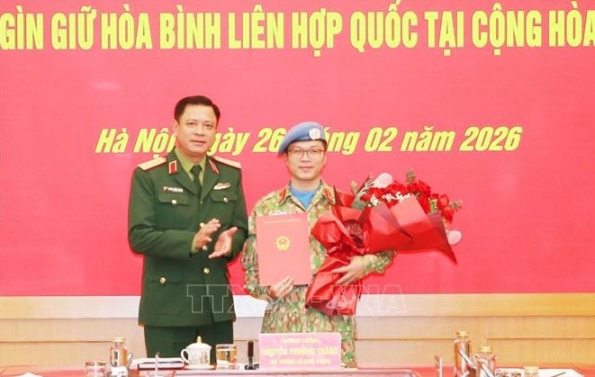 Senior Lieutenant General Nguyen Truong Thang, Deputy Minister of National Defence, presents the President's decision to Lieutenant Colonel Nguyen Hoang Long.