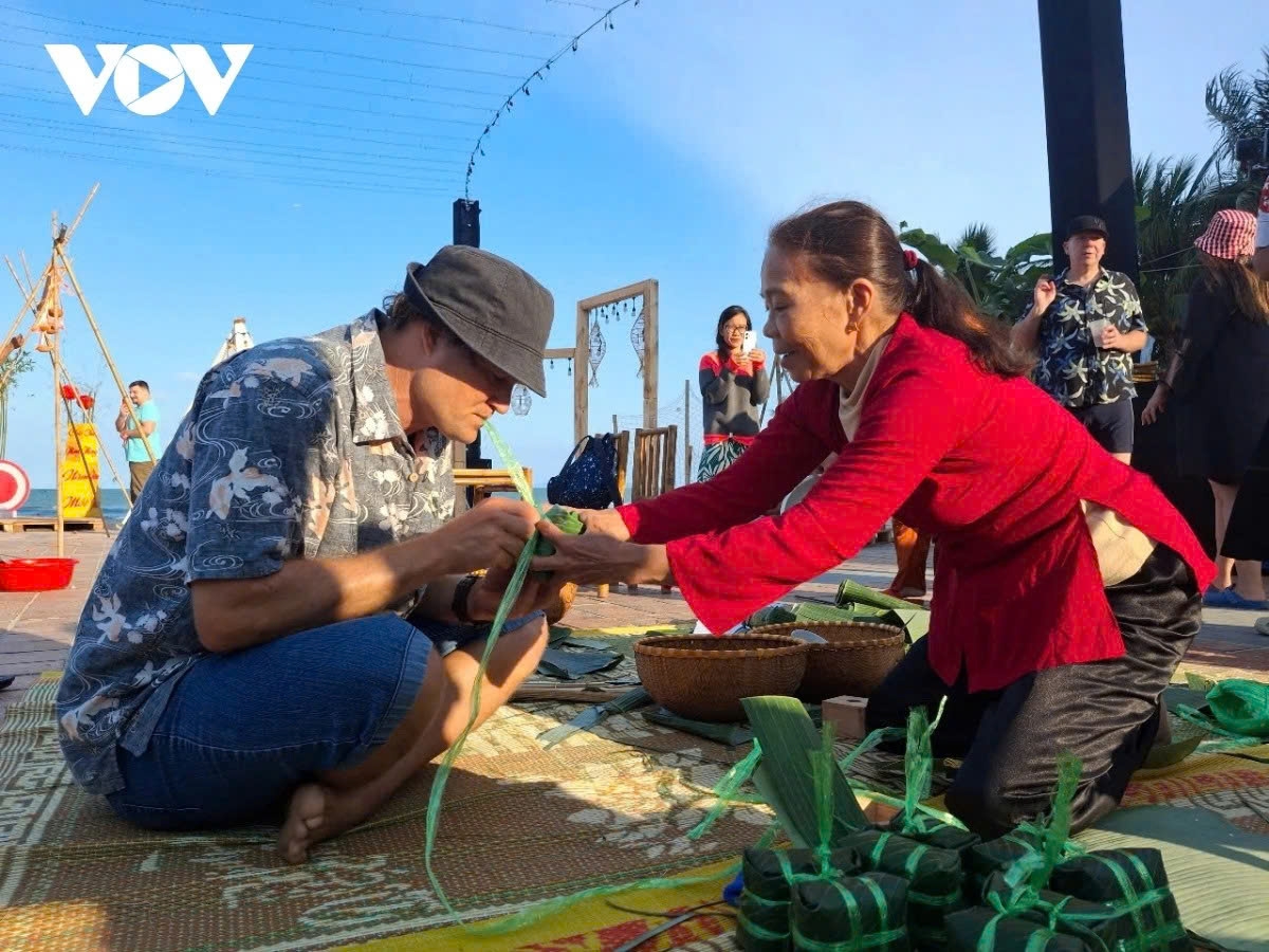 A foreign visitor learns how to wrap Bánh chưng (Square glutinous rice cake).