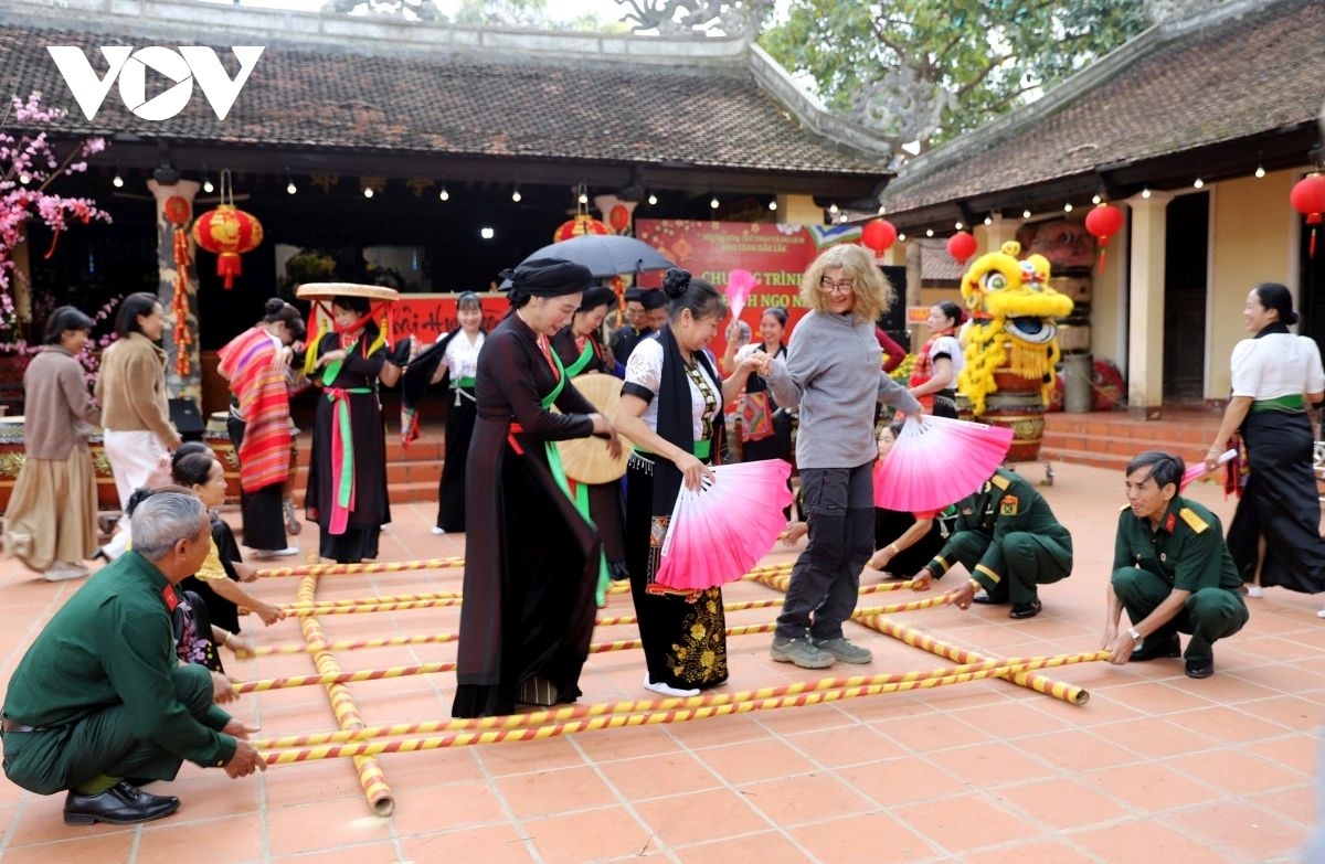 Foreign visitors experience the traditional bamboo dance of Vietnam’s ethnic highland people