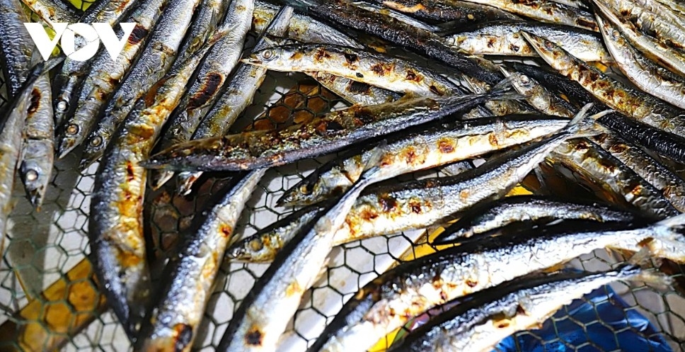Another type of fish is taken off the grill just as it finishes cooking.