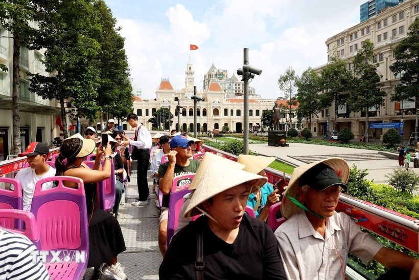 International tourists visit Ho Chi Minh City's downtown area by double-decker bus.