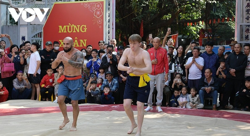 Two wrestlers, Rafael (Russia) and Smith Harry (United Kingdom), compete for the third-place prize amid enthusiastic cheers from residents and visitors.