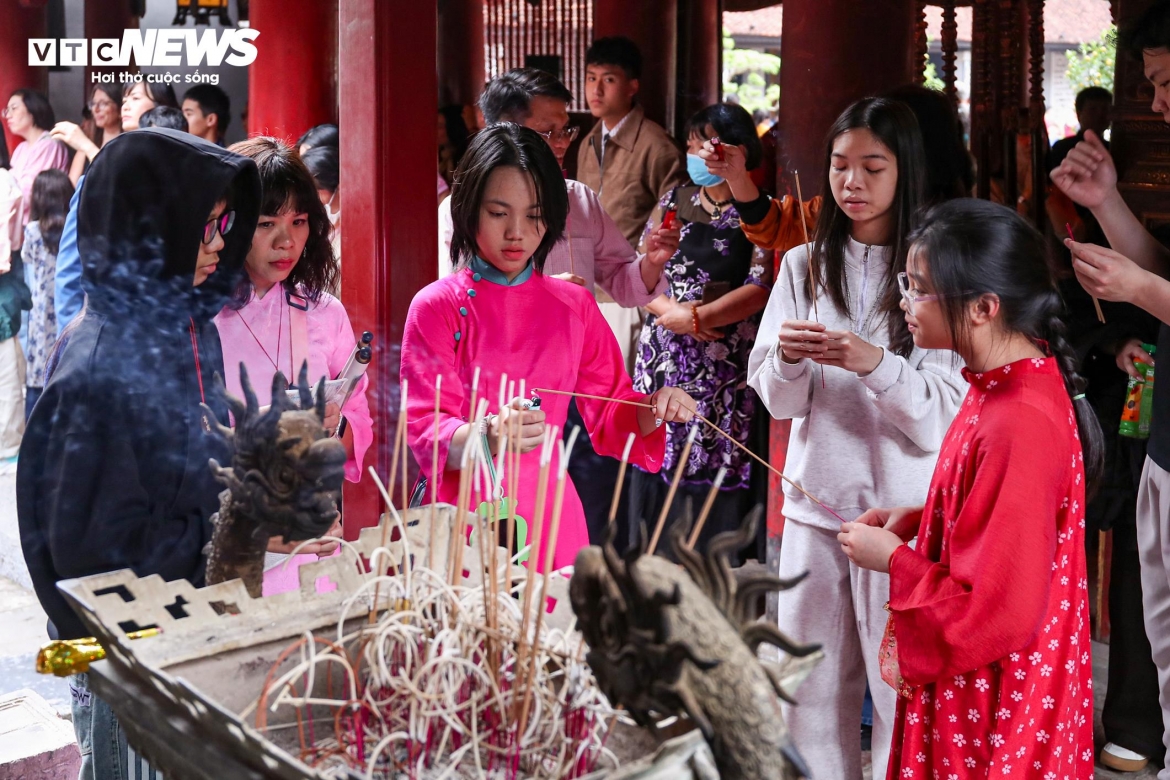    Young people are among the steady stream of visitors making offerings at the worship area dedicated to Confucius and Chu Van An.
