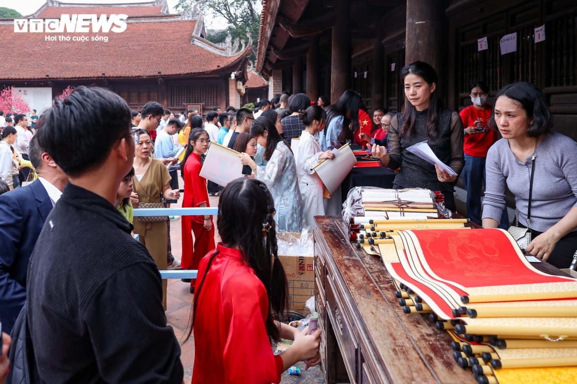 Visitors queue to buy paper before waiting their turn to receive calligraphy.