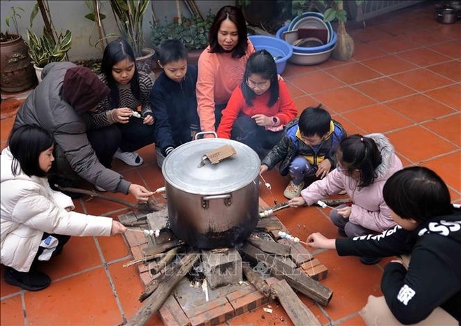 Watching the pot of banh chung is a cherished pastime for children whenever the Lunar New Year arrives.