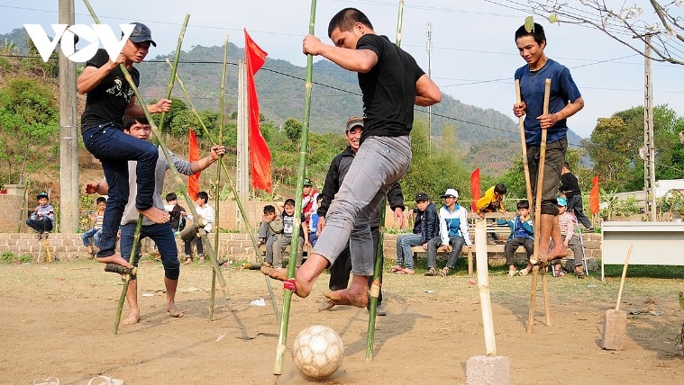 Thai young men on a football field playing on stilts