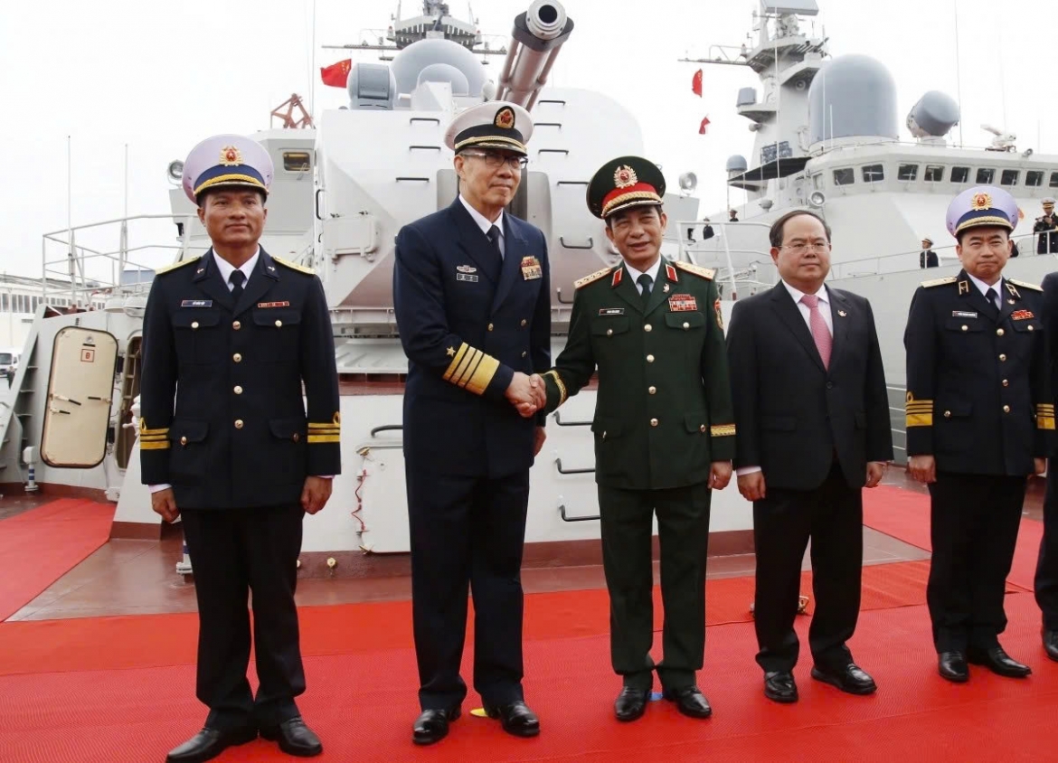 The Defence Ministers of Vietnam and China pose for a photo ahead of the vessels' departure for the joint patrol