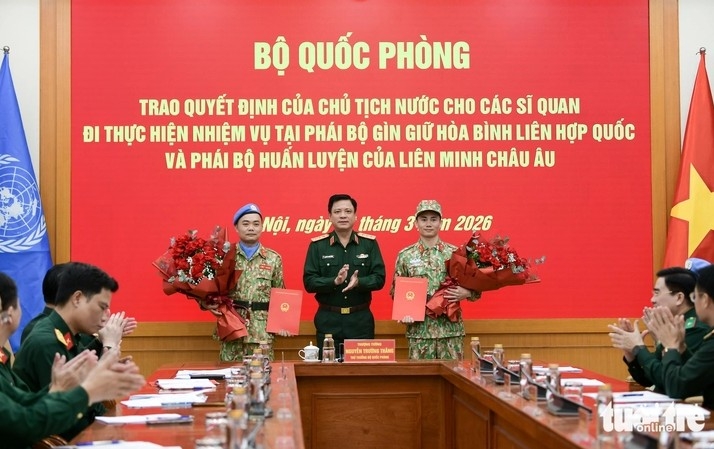 Senior Lieutenant General Nguyen Truong Thang presents decisions and flowers to the two officers. (Photo: tuoitre.vn)