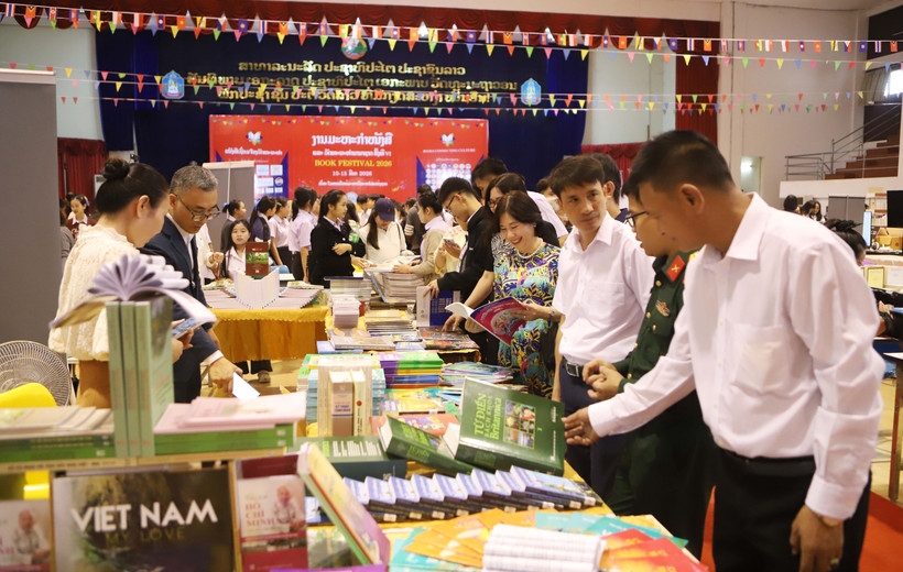 Delegates visit the book display booth of the Vietnamese Embassy in Laos