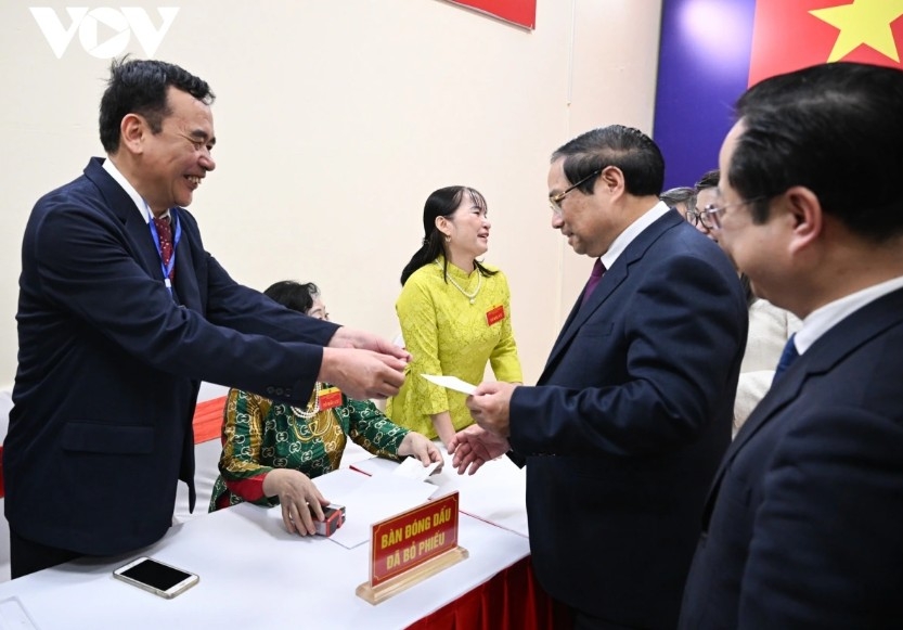At 6:30 a.m., Prime Minister Pham Minh Chinh and his spouse Le Thi Bich Tran arrive at the polling station, where they are welcomed by voters and members of the election team.