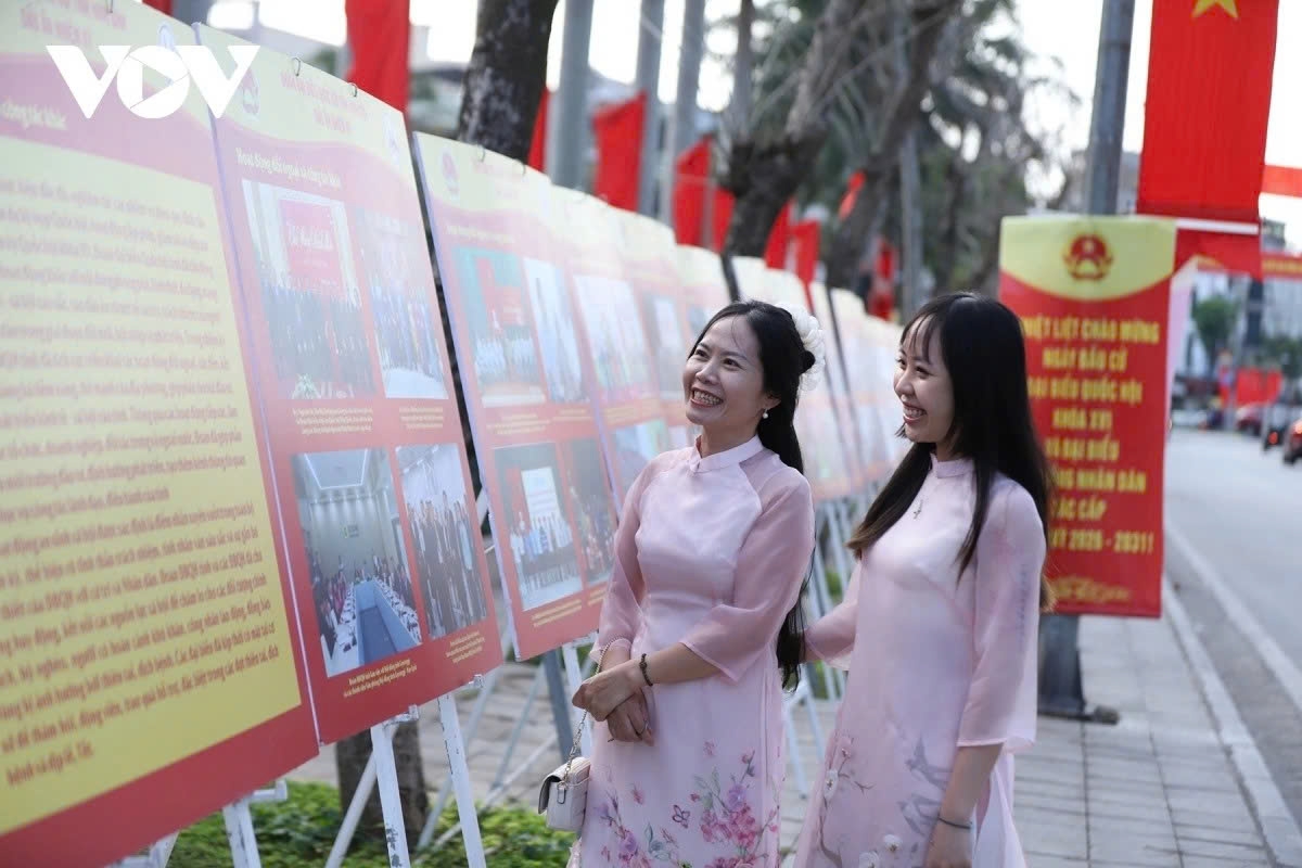 Residents stop to view election banners and posters displayed along a central street.