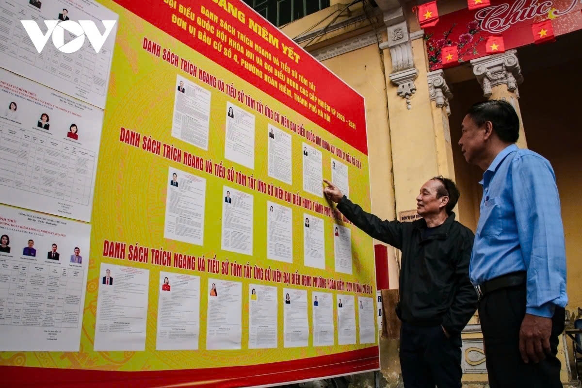 Nguyen Khac Chung (right), secretary of the Hang Buom 1 residential group Party cell, is present at a polling station to observe preparations ahead of election day.