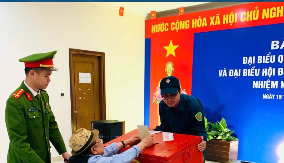 An elderly war veteran casts his ballot with assistance from officials at the polling station, leaving a moving image of civic responsibility and democratic participation on election day for the 16th National Assembly and People’s Councils at all levels for the 2026-2031 term.