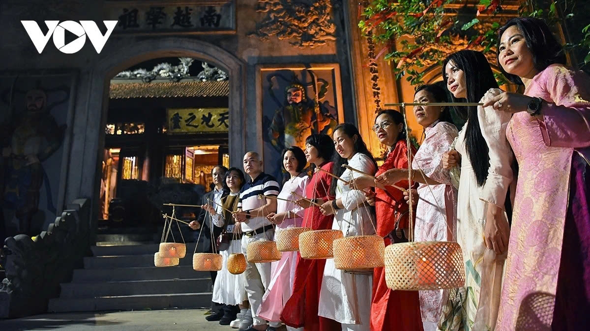 Visitors take photos with lanterns in front of Thuong Temple after offering incense to the Hung Kings.