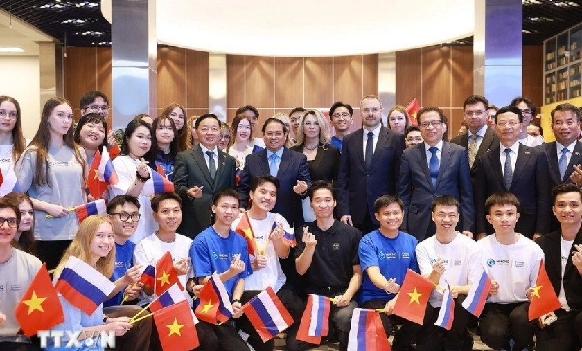 PM Pham Minh Chinh pose for a group photo with the university's leaders and Vietnamese students (Photo: VNA)