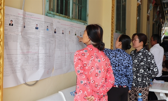 Khmer residents of Nga Cay Hamlet, Xa Phien Commune, Cần Thơ, review candidate information.