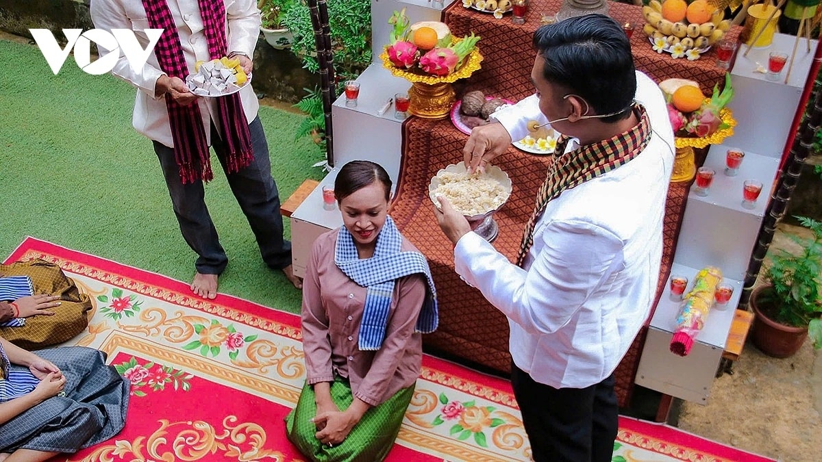 The ritual leader mixes flattened rice with bananas and sweet potatoes, then feeds it to each participant - a symbolic act of sending their wishes to the Moon deity during the festival.
