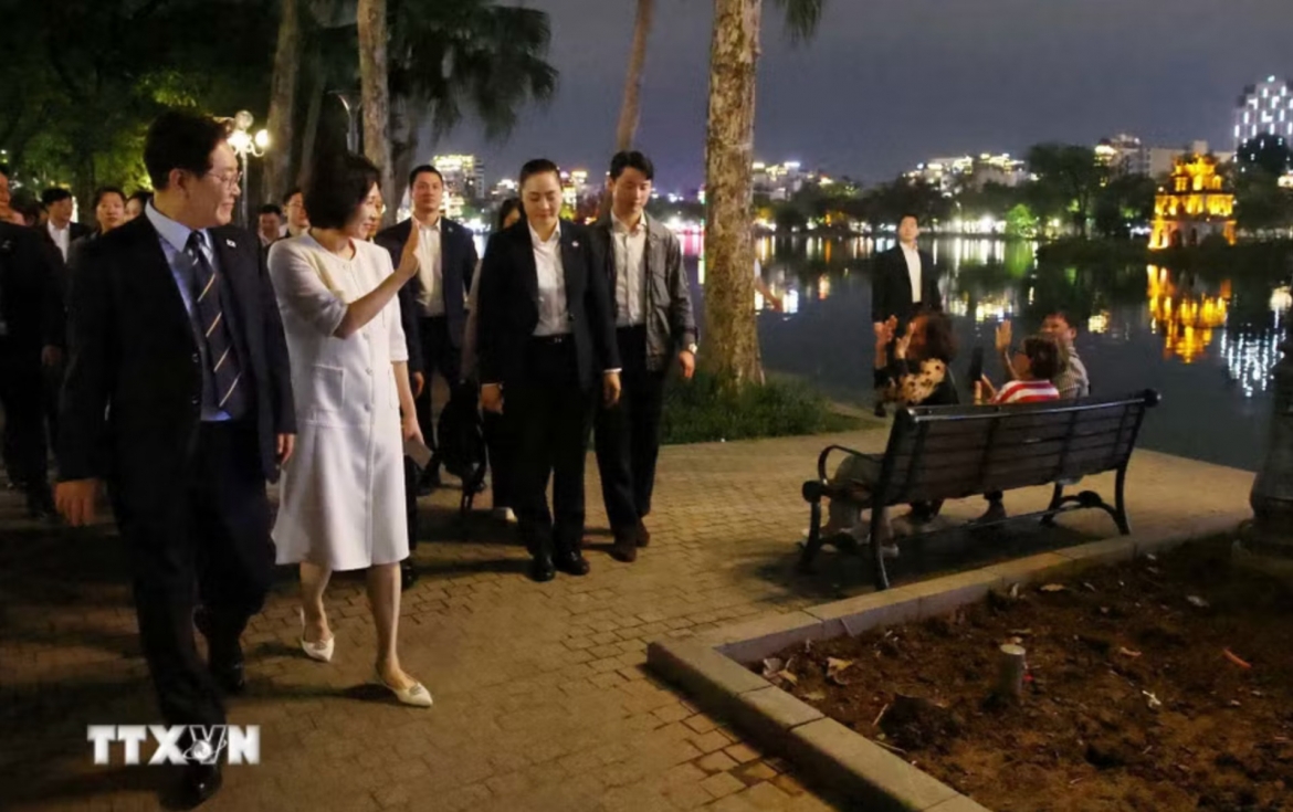 RoK President Lee Jae-myung and First Lady Kim Hye-kyung wave at Hanoi residents while taking an evening stroll around Hoan Kiem Lake on April 23. (Photo: VNA)