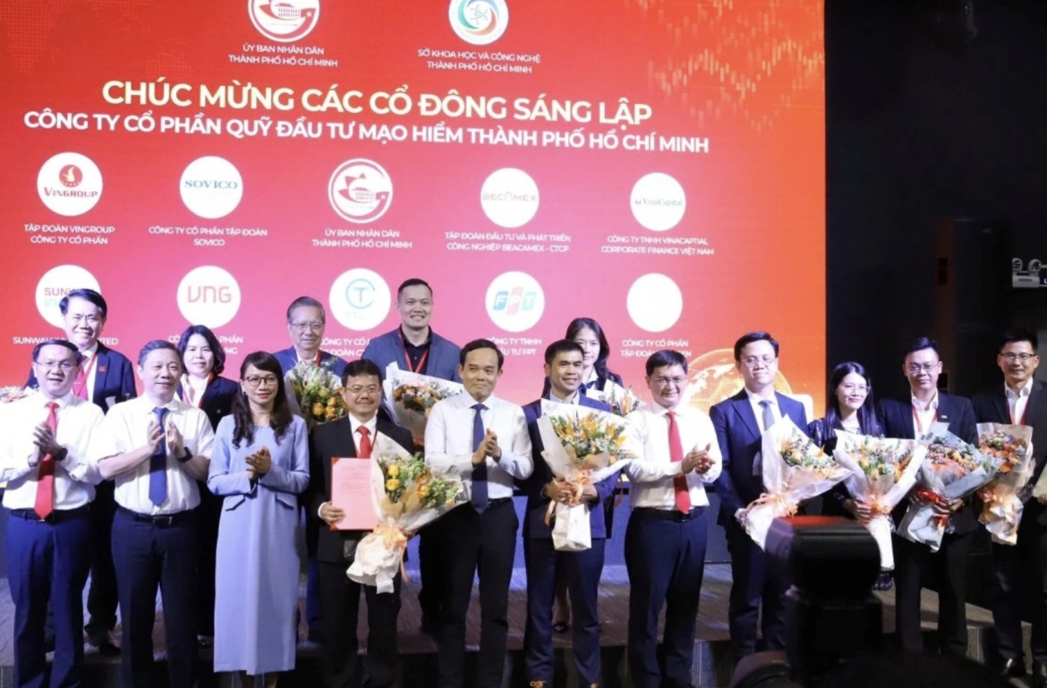 Ho Chi Minh City Party Secretary Tran Luu Quang (C) and city leaders present business registration certificates and flowers to congratulate the founding shareholders of the Ho Chi Minh City Venture Capital Fund