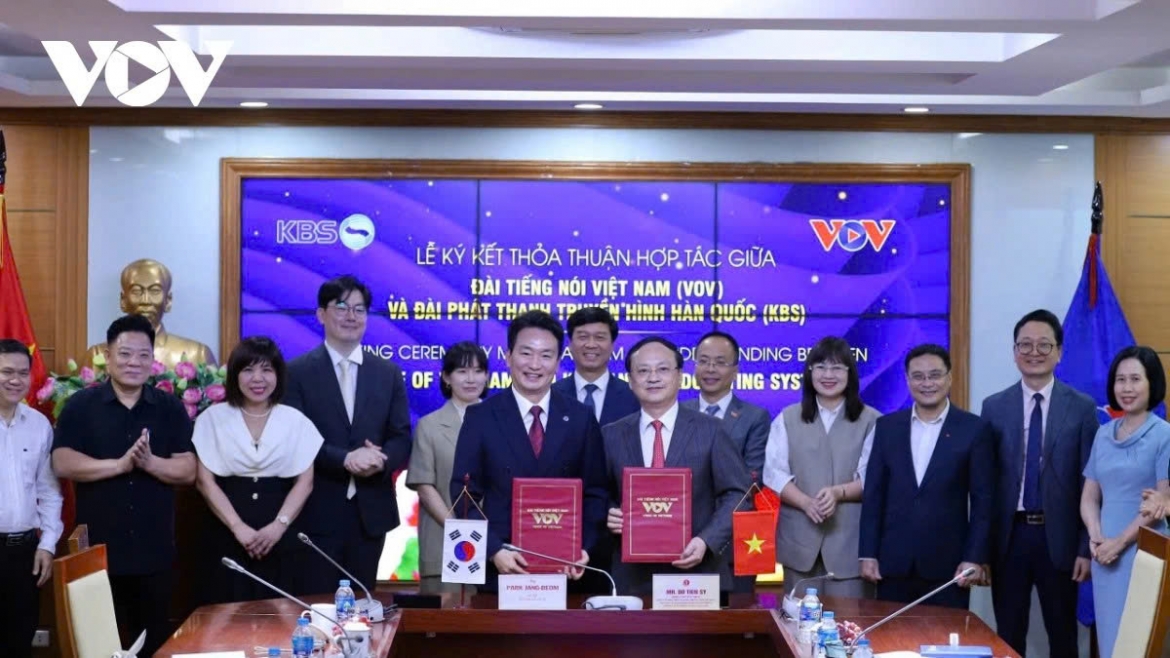VOV President Do Tien Sy and KBS President Park Jang-beom pose for a photo alongside other officials from the two media organisations