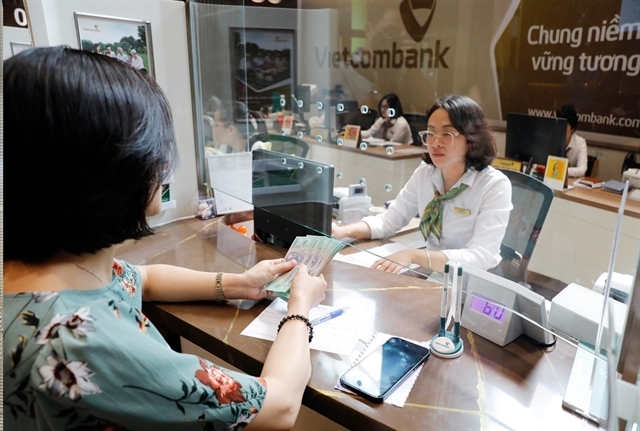 Transactions at Vietcombank. Nearly 20 commerical banks cut deposit rates over April 10–11, in line with commitments made to the State Bank of Vietnam. — VNA/VNS Photo Tran Viet