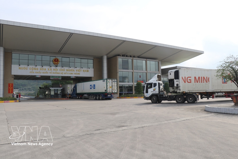 Trucks carrying import and export goods pass through the Lao Cai border gate. (Photo: VNA)