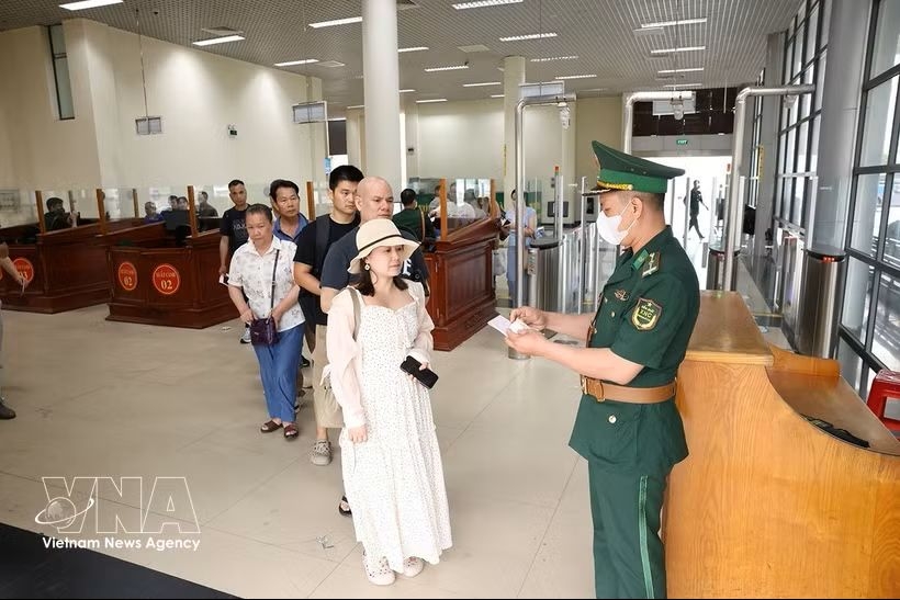 A border guard at the Mong Cai International Border Gate processes exit procedures for passengers at the Bac Luan 1 border gate in Quang Ninh province.