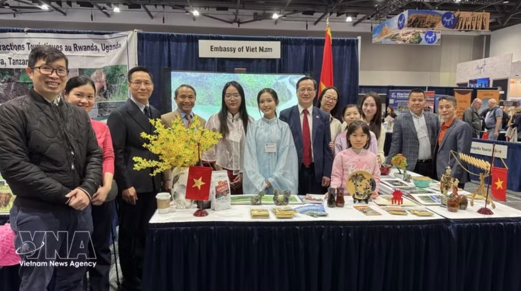 Ambassador Pham Vinh Quang (seventh from left) poses for a photo with staff of the Vietnamese Embassy in Canada at the Vietnam booth at the exhibition. (Photo: VNA)