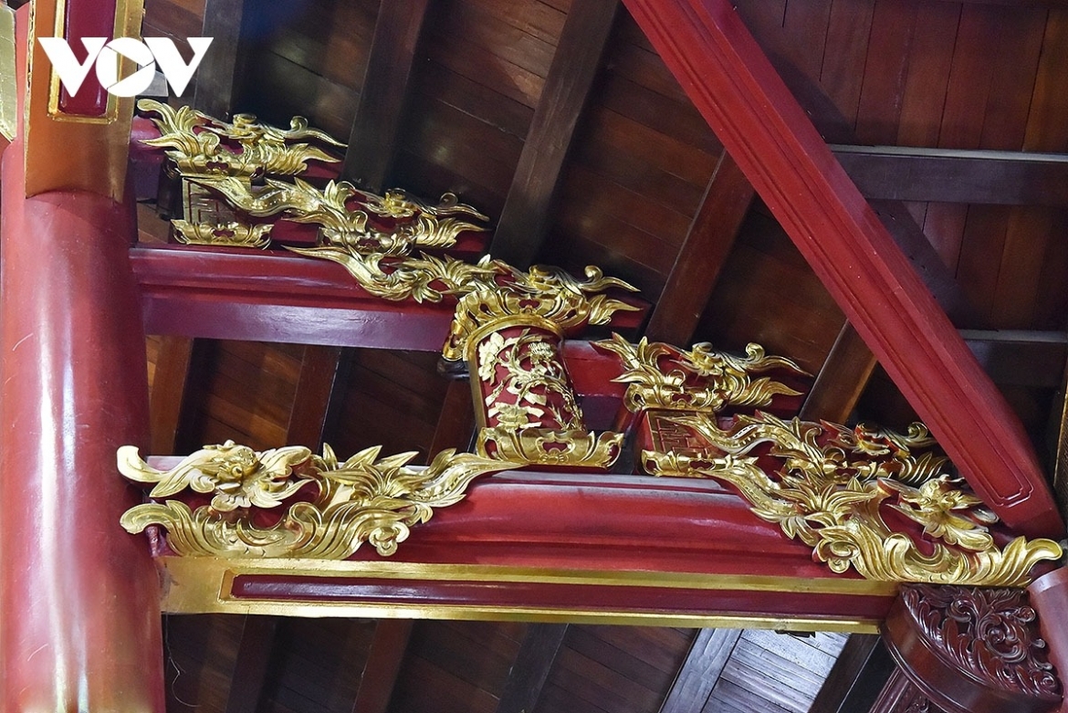 Intricate carvings with red lacquer and gilded finishes reflect the distinctive style of traditional Vietnamese communal houses and pagodas.