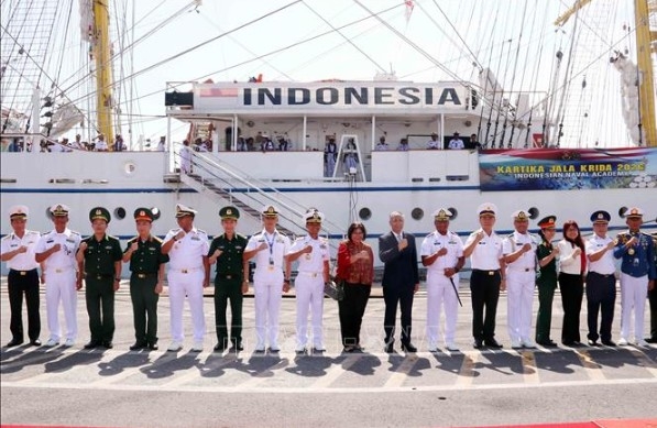 Delegates from Vietnam and Indonesia pose for a photo in front of the Indonesian Navy’s KRI Bima Suci (Photo: VNA)