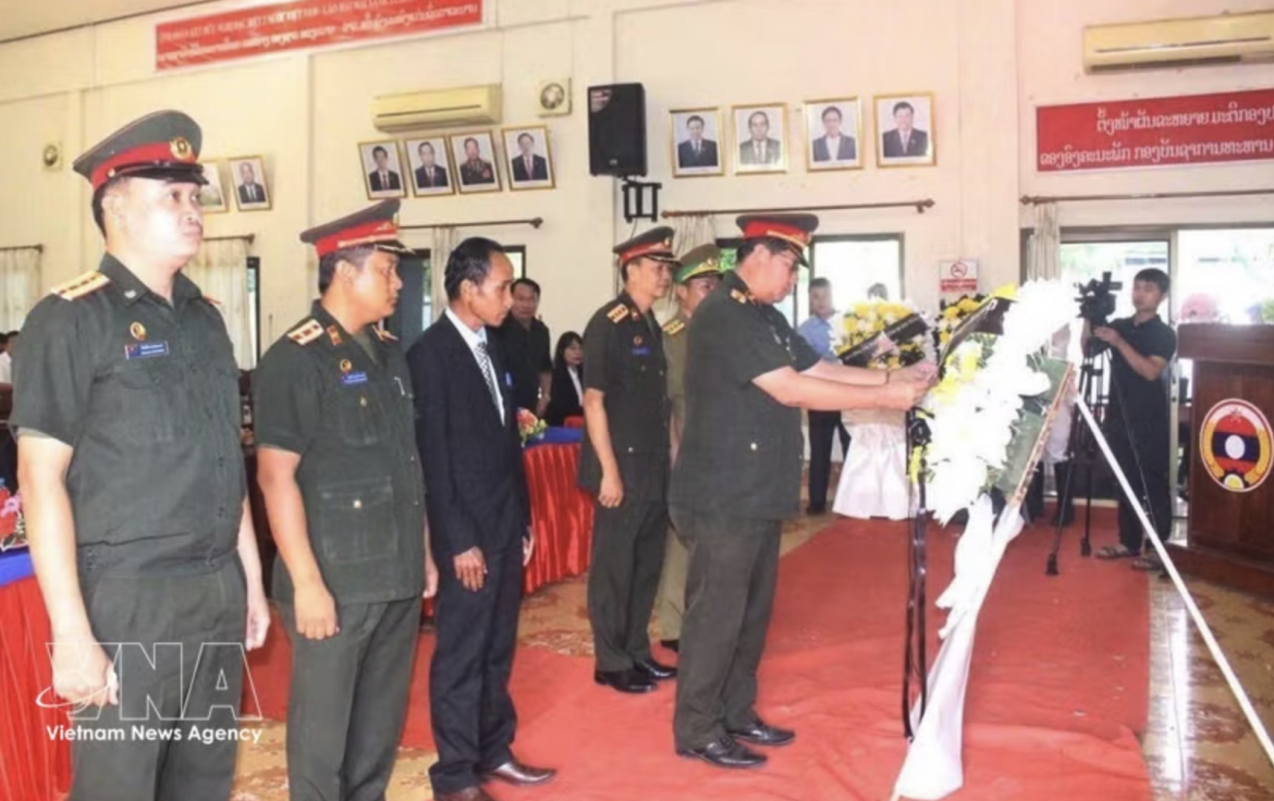 Representatives of the armed forces of southern Lao provinces offer flowers at the ceremony. (Photo: VNA)