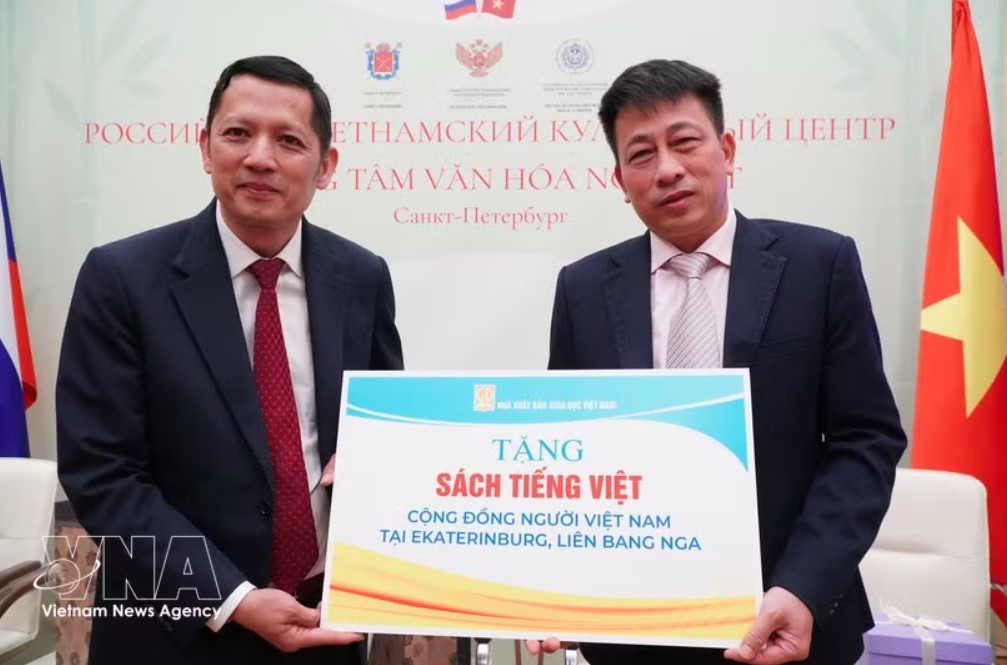Editor-in-Chief of the Education Publishing House Pham Vinh Thai (right) symbolically presents books to the Vietnamese community in Russia. (Photo: TVNA)