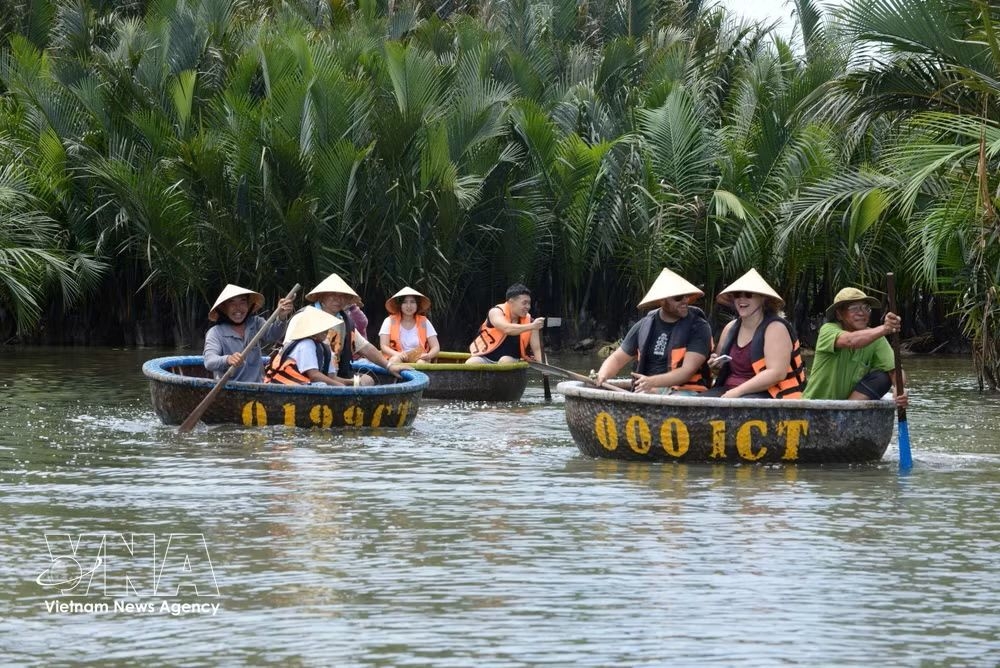 Tourists visit the Bay Mau coconut forest in Hoi An Dong ward, Da Nang city.