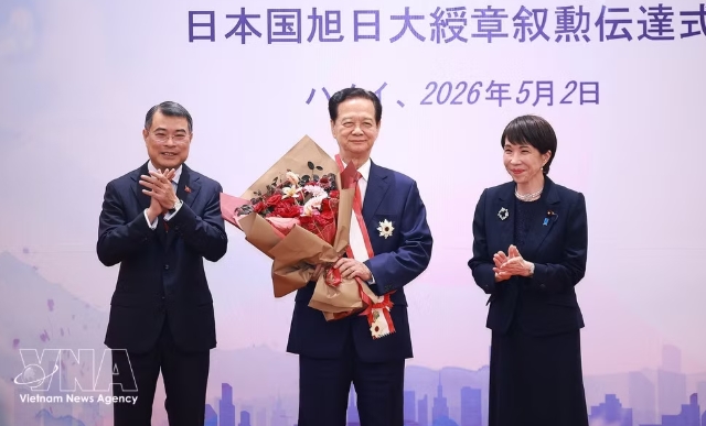 Prime Minister Le Minh Hung (left) presents flowers as Japanese Prime Minister Takaichi Sanae awards the Grand Cordon of the Order of the Rising Sun to former Prime Minister Nguyen Tan Dung. (Photo: VNA)