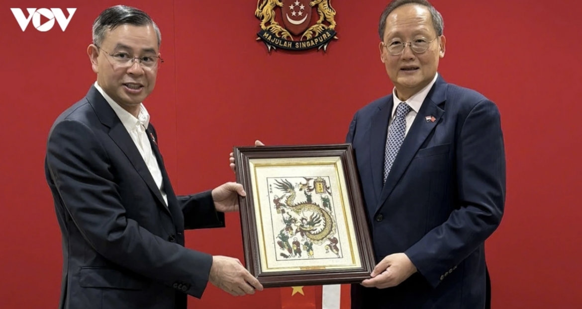 Vietnam's Minister of Finance Ngo Van Tuan presents a gift to Singapore's Minister for Manpower and Second Minister for Trade and Industry Tan See Leng