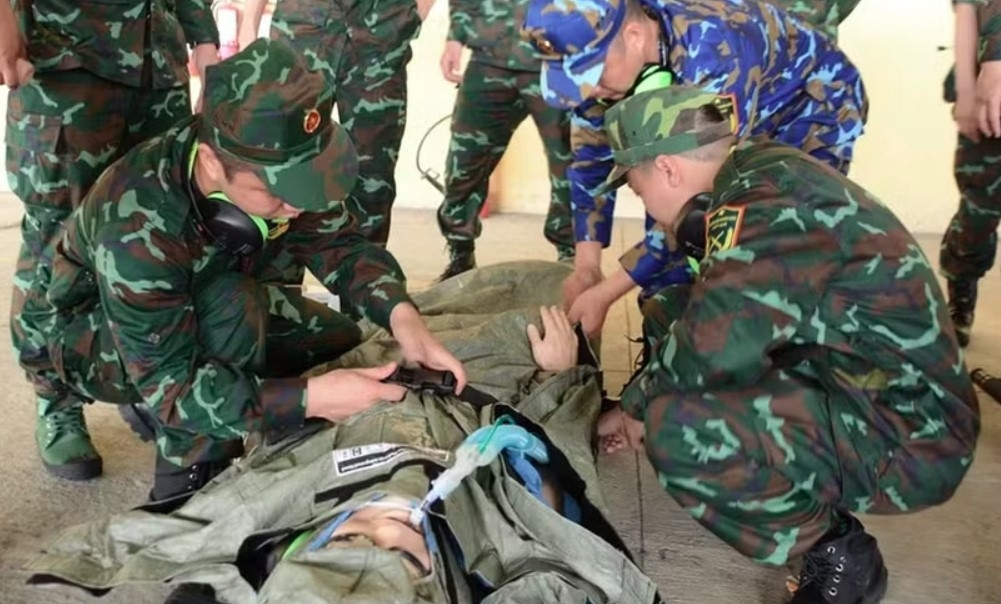 AMET members practise receiving and securing a patient on a stretcher in preparation for transport to an ambulance (Photo: VNA)