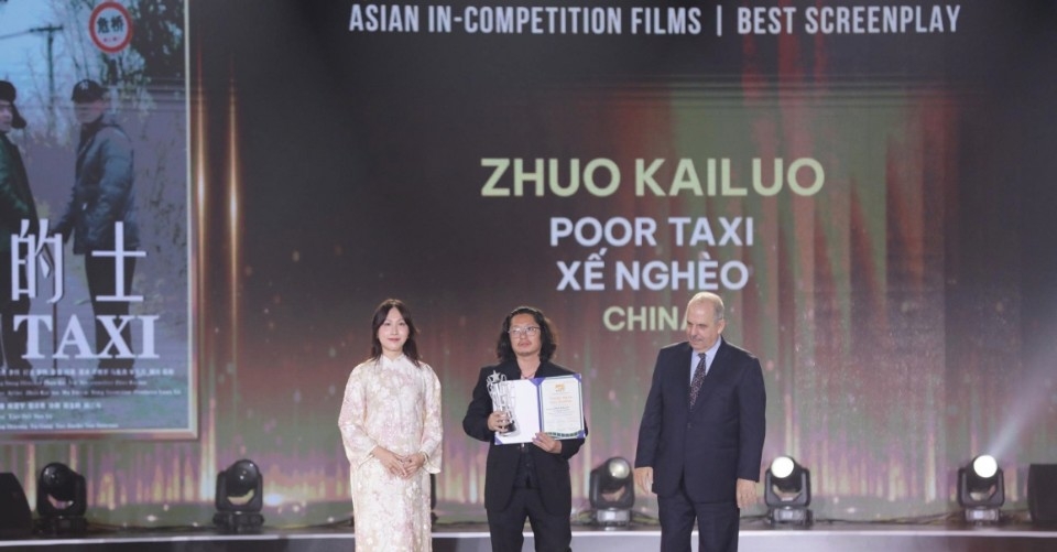 Chinese screenwriter Zhuo Kailuo receives the Best Screenplay award in the Asian Film Competition for Poor Taxi